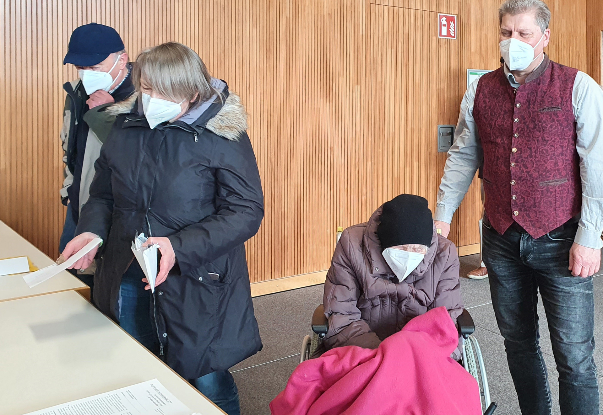 Bürgermeister Harald Zipfel (r.) begleitet die Erste Impfanwärterin zur Anmeldung.