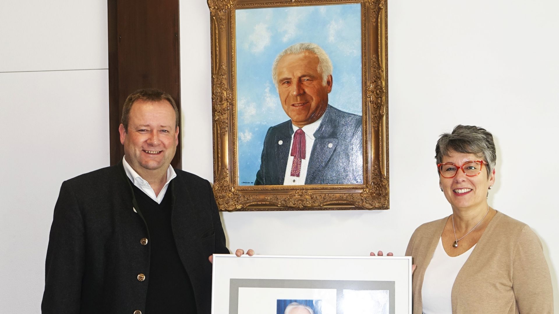 Bürgermeister Peter Köstler mit Archivarin Monika Frank vor dem Portrait von Sigi Segl (Foto: Gemeinde Gräfelfing)